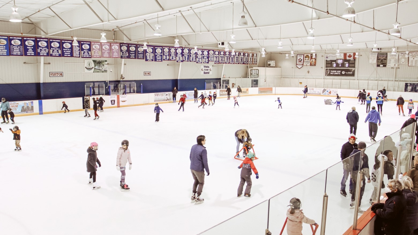 Multiple people skating indoors on ice