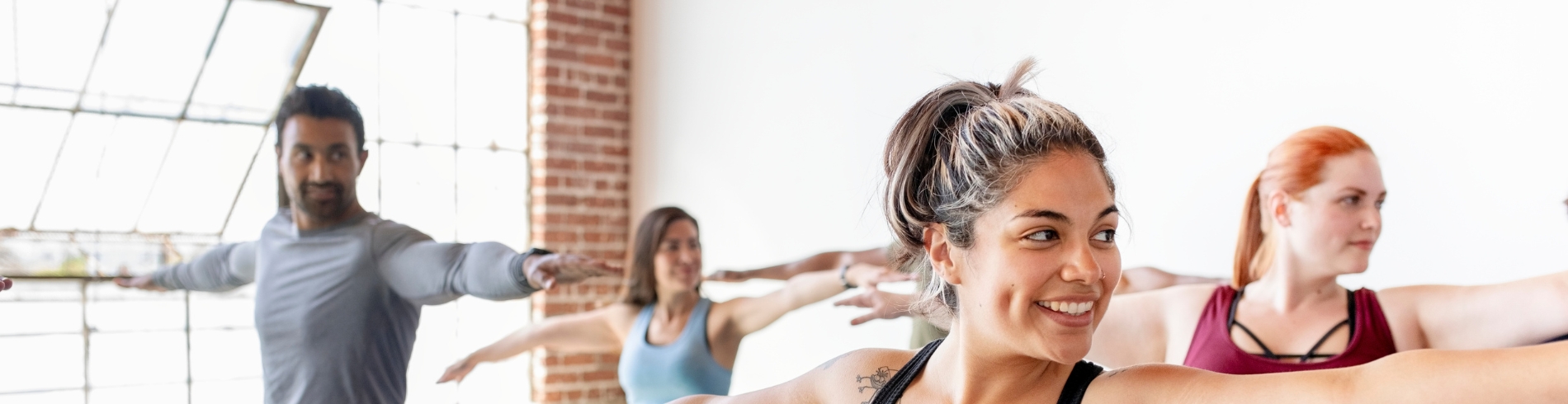 Adults doing yoga together inside a gym